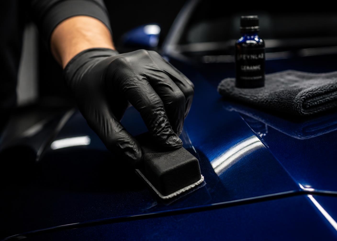 Ceramic coating being hand-applied to a deep blue panel in the Bridgend unit